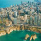 Aerial view of Beirut coastline with dense urban skyline, Mediterranean Sea, and rocky limestone cliffs with Pigeon Rocks